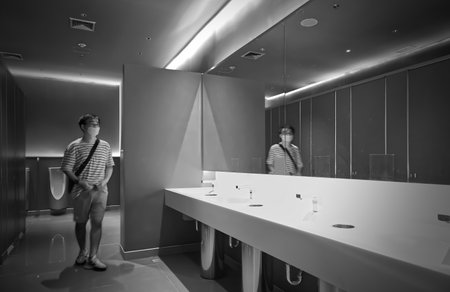 A man in a restroom in shopping mall on Sukhumvit road Bangkok Thailand