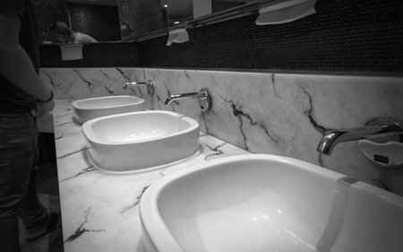 A man in a men's restroom in a shopping mall on Sukhumvit road Bangkok Thailand