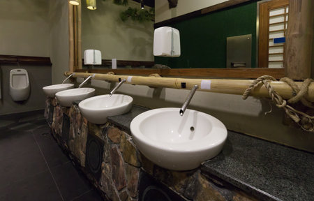 Public empty men restroom with washstands mirrors in shopping mall, Bangkok, Thailandの写真素材
