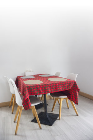 Dining table with red plaid tablecloth in a restaurant, interior backgroundの写真素材