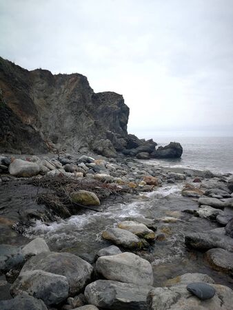 Gray sky at a stone coastの写真素材