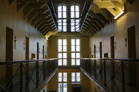 Looking down a deserted aisle lined on both sides with three levels of prison cells.のeditorial素材