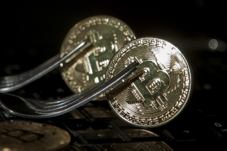 Golden bitcoins with forks. Hard fork change conceptの写真素材