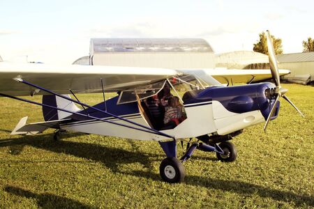beautiful baby girl sitting in the cockpit of a small two-seater plane
