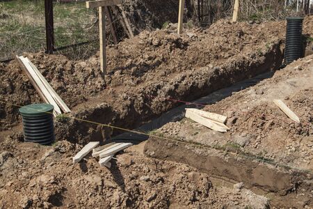 view of drainage pipes and inspection well for removal of water from a site under construction of the houseの写真素材