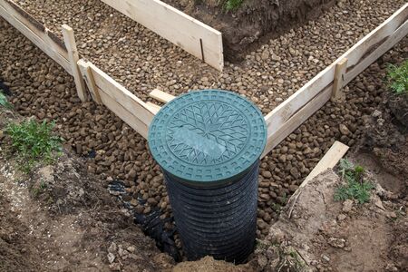 inspection well, drainage pipe and trench with formwork, which is prepared for pouring the foundationの写真素材