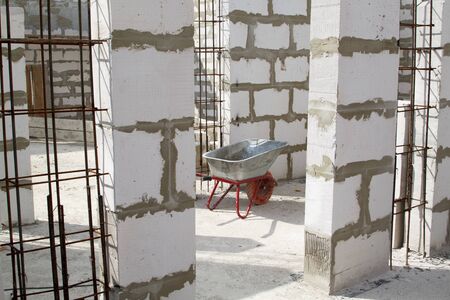 close up view of interior of a country house under construction. Site on which the walls are built of gas concrete blocks and wheelbarrowの写真素材