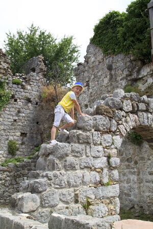 boy climbs the ruins of an ancient buildingの写真素材