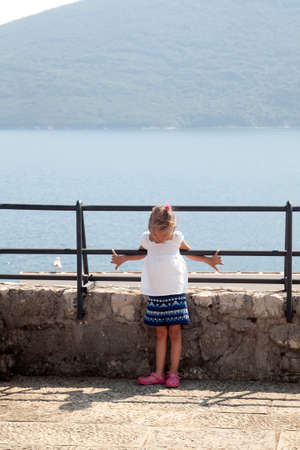 frowned girl is depicted on the observation deck with a breathtaking spectacular view of the Boka-Kotorska bay from the fortress Herceg Novi, Montenegroの写真素材