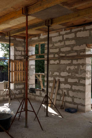 view of the wooden formwork with metal holders, which will be filled with the overlap between the floors in the country house under construction from the foam blockの写真素材