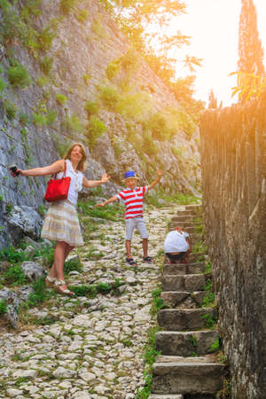 family value. happy mother with her son and daughter climbs the mountain up the steps to see the...