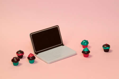 Cupcakes with laptop on pink pastel backgroundの写真素材