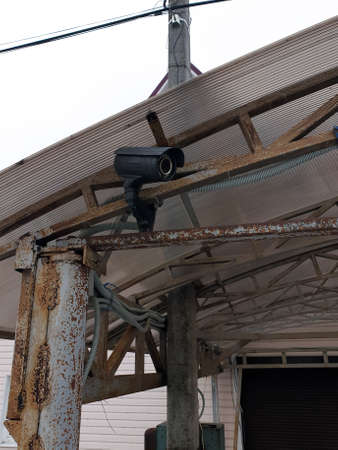Surveillance and safety home concept. Security CCTV camera monitoring perimeter of private house in...