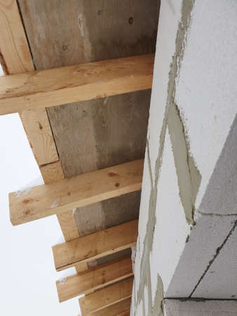 close-up view of corner of house with scaffolding, where preparatory work is carried out before...