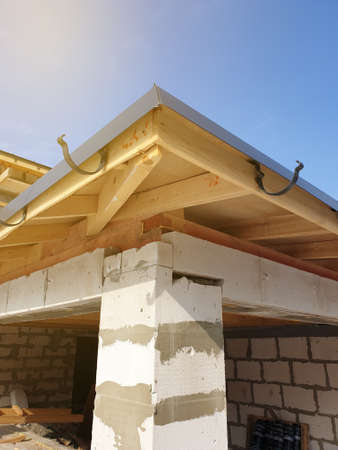 close up view of house under construction with holders for gutters water drainage system