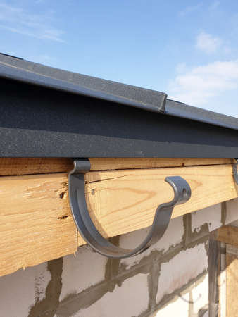 close up view of house under construction with holders for gutters water drainage system