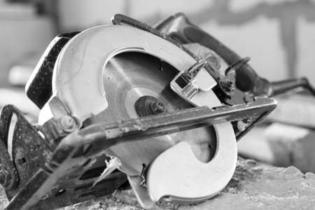 manual circular saw is on a wooden board