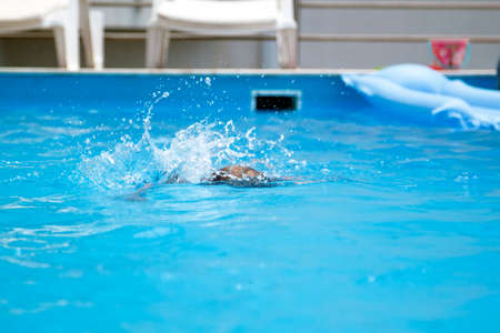 splash from a boy swimming in a poolの写真素材