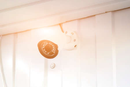 white CCTV surveillance camera mounted on wall of building