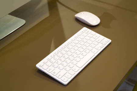 close up view of beige desk with white keyboard and mouse next to display