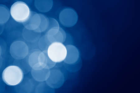 abstract blurred circular bokeh lights background toned in trendy Classic Blue color of the Year 2020の写真素材