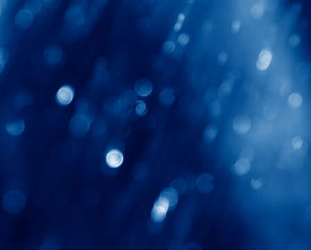 Abstract green blurred natural background with bokeh toned in trendy Classic Blue color of the Year 2020の写真素材