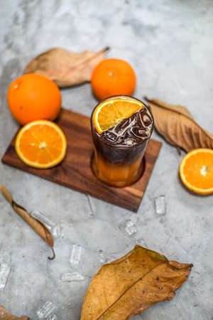 Fresh orange juice and citrus fruits Vitamin C has health benefits, fresh, flaky, sweet, arranged on a wooden tray, leaves, and round ice cubes. Concept healthy drinks and increasing energy.の写真素材