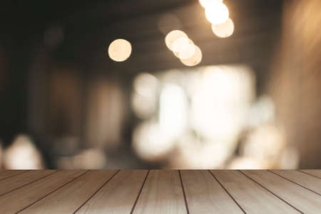 The surface on the empty wooden table and the blur background of the kitchen in the cafe. Can be used as a background for presenting products.の写真素材