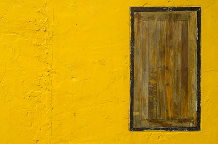 Window on yellow cement wallの写真素材