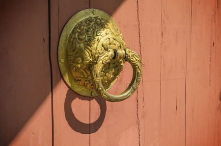 Old door handle on wood door and sunlightの写真素材