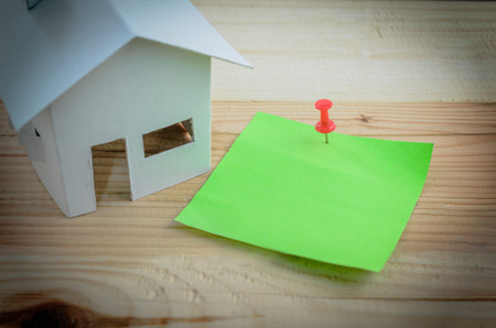 Miniature house and paper note on woodenの写真素材