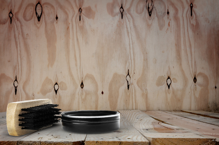 container of shoe polish and brush on wooden backgroundの写真素材