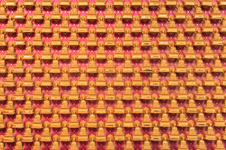Many Chinese golden Buddha statues are placed on red walls in Chinese temples.の写真素材