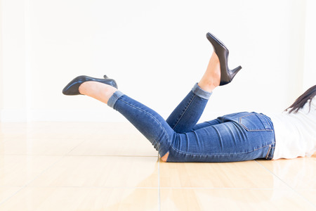 Woman blue jeans Wearing High-heeled shoes ,sitting cross-legged On a white backgroundの写真素材