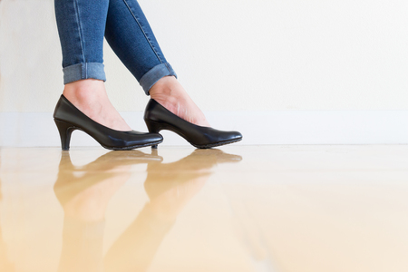 Woman blue jeans Wearing High-heeled shoes ,sitting cross-legged On a white backgroundの写真素材
