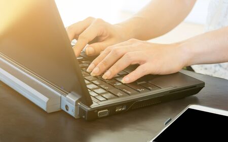 Woman typing laptop computer on the desk.の写真素材