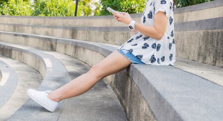 Woman legs wearing white shoes sitting sport.の写真素材