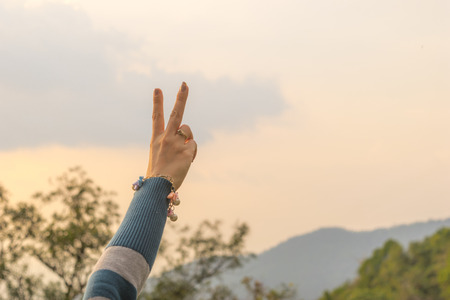 Woman travel hands two fingers Natural backgroundの写真素材