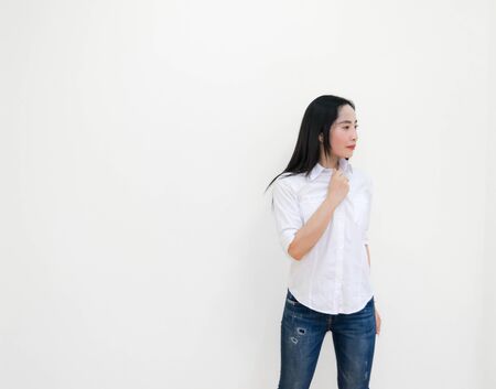 Asian young woman thinking beautiful smile put a white shirt stand of on white background.の写真素材