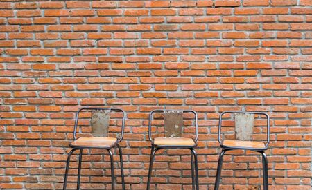 Brick wall, wooden window doors and chairsの写真素材