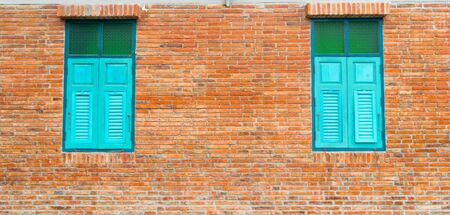 Brick walls and blue wooden windowsの写真素材