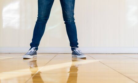 Jeans and shoes Legs standing on the floor.の写真素材