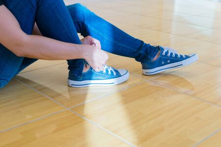 Jeans and shoes Legs standing on the floor.
