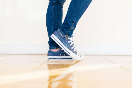 Jeans and shoes Legs standing on the floor.