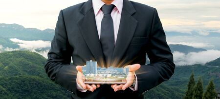 Ecology concept human hands holding building with on world environment dayの写真素材