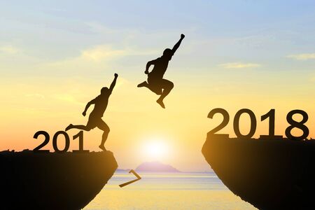 Men jump over silhouette Happy New Year 2018の写真素材