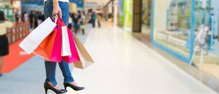 Female walks hands holding shopping bags and credit card in the mallの写真素材