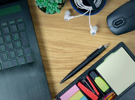 computer Laptop a mouse of cactus the pen and earphone on the wood tableの写真素材