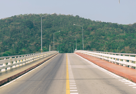 Road bridge over the sea mountainous backgroundの写真素材