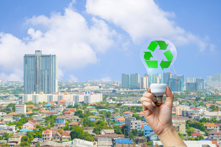 recyclable environment human hands holding big plant tree in light bulb withの写真素材